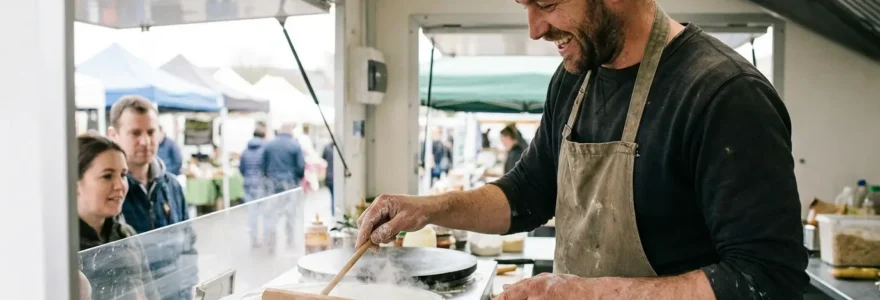 Entrepreneur préparant des crêpes sur bilig professionnel dans son camion crêperie au marché